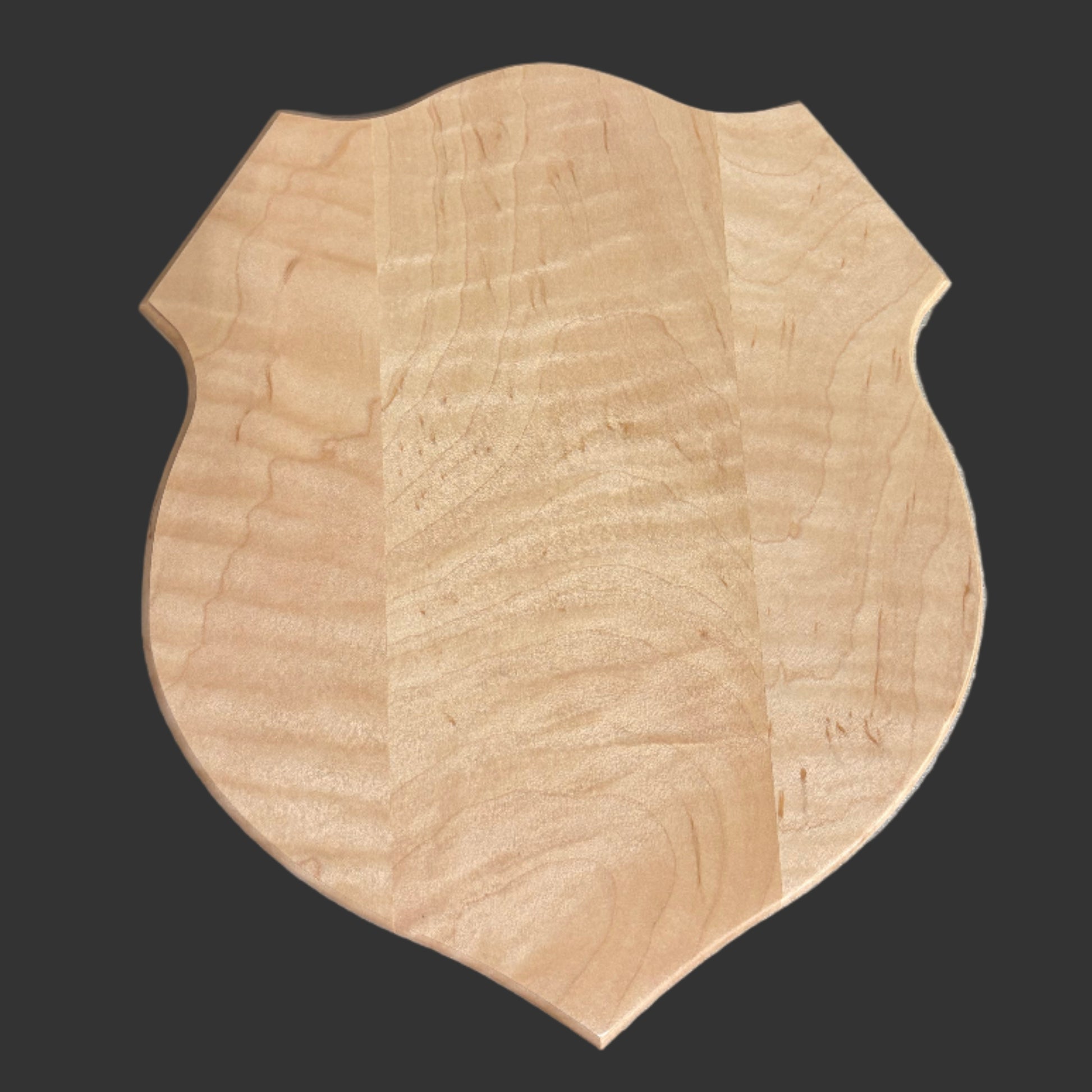 Wooden craft item on a gray surface next to a laptop