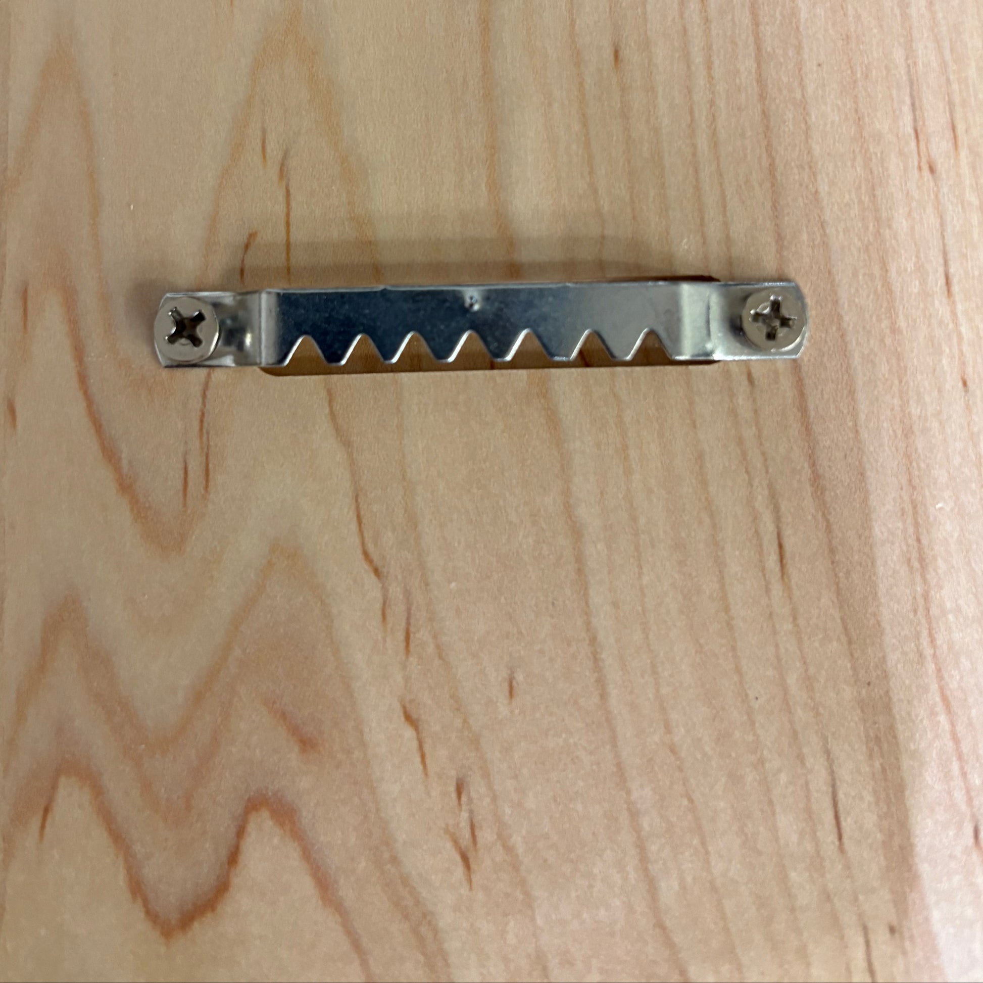 Metal tool with a serrated edge on a wooden surface